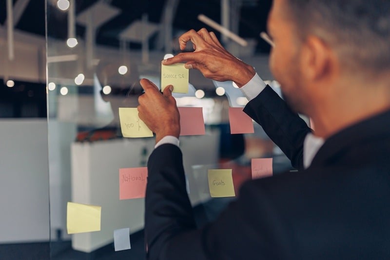 close-up-of-businessman-is-glues-sticky-notes-on-m-2023-11-27-05-19-09-utc